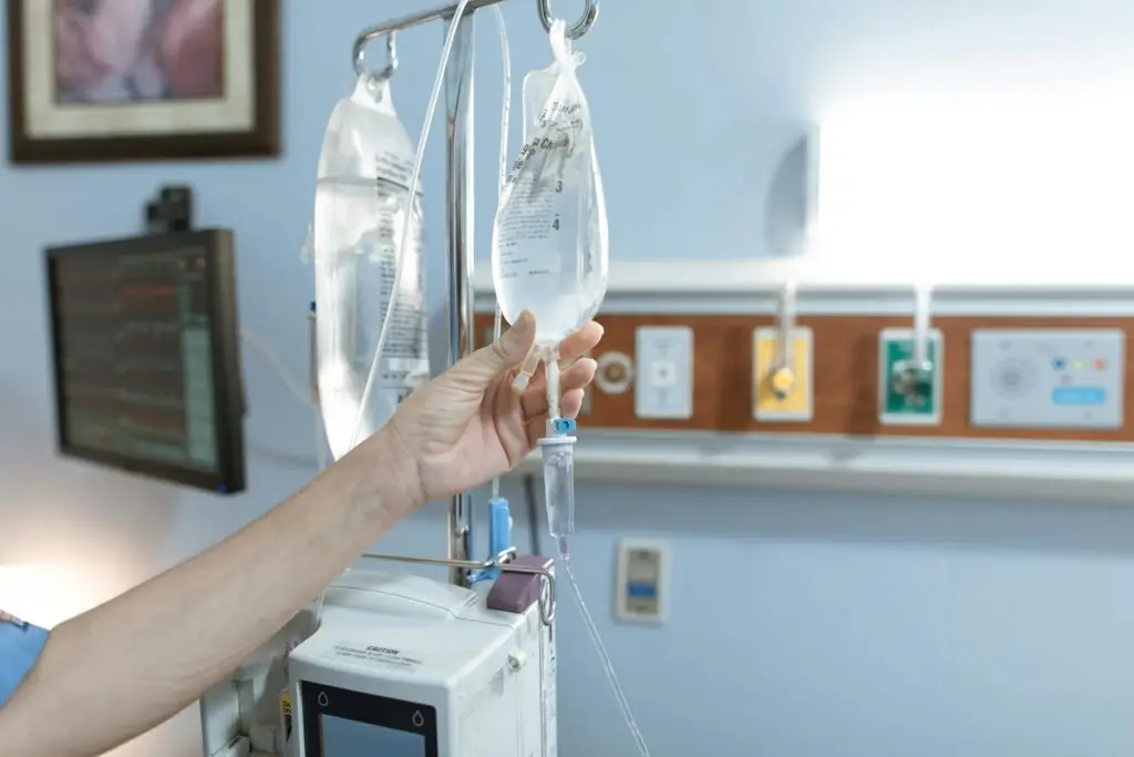 Shock-management-emergency-classification What is shock? Shock management in emergency. Close-up image of an IV drip and hand in a hospital room, illustrating medical care.
